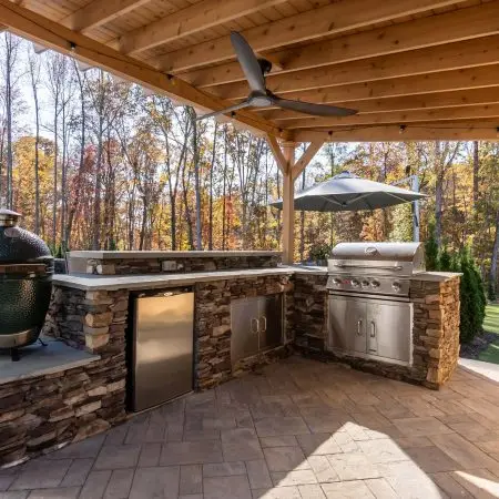 Stone veneer custom grill island with bar top, egg, and Bull appliances in Raleigh, NC
