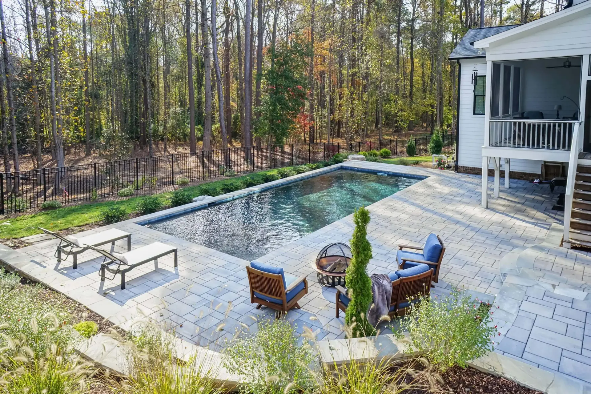 Wake Forest rectangular custom built luxury pool with Pebbletec plaster, Techo Bloc pavers, landscaping, and retaining wall