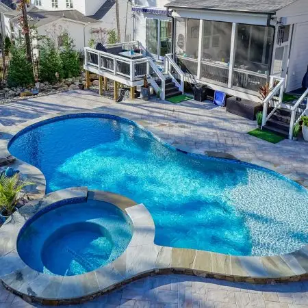 Close up of custom pool in Pittsboro, NC with waterfall, spa, and pavers.