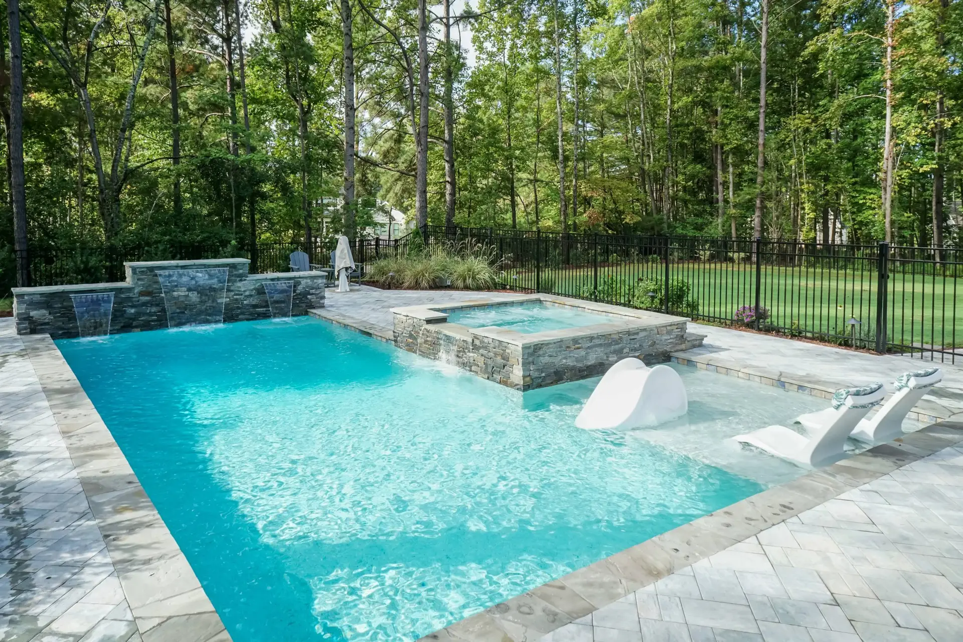Toll Mill Vista Escape luxury custom linear pool with spa and water feature wall - angle view in Raleigh, NC