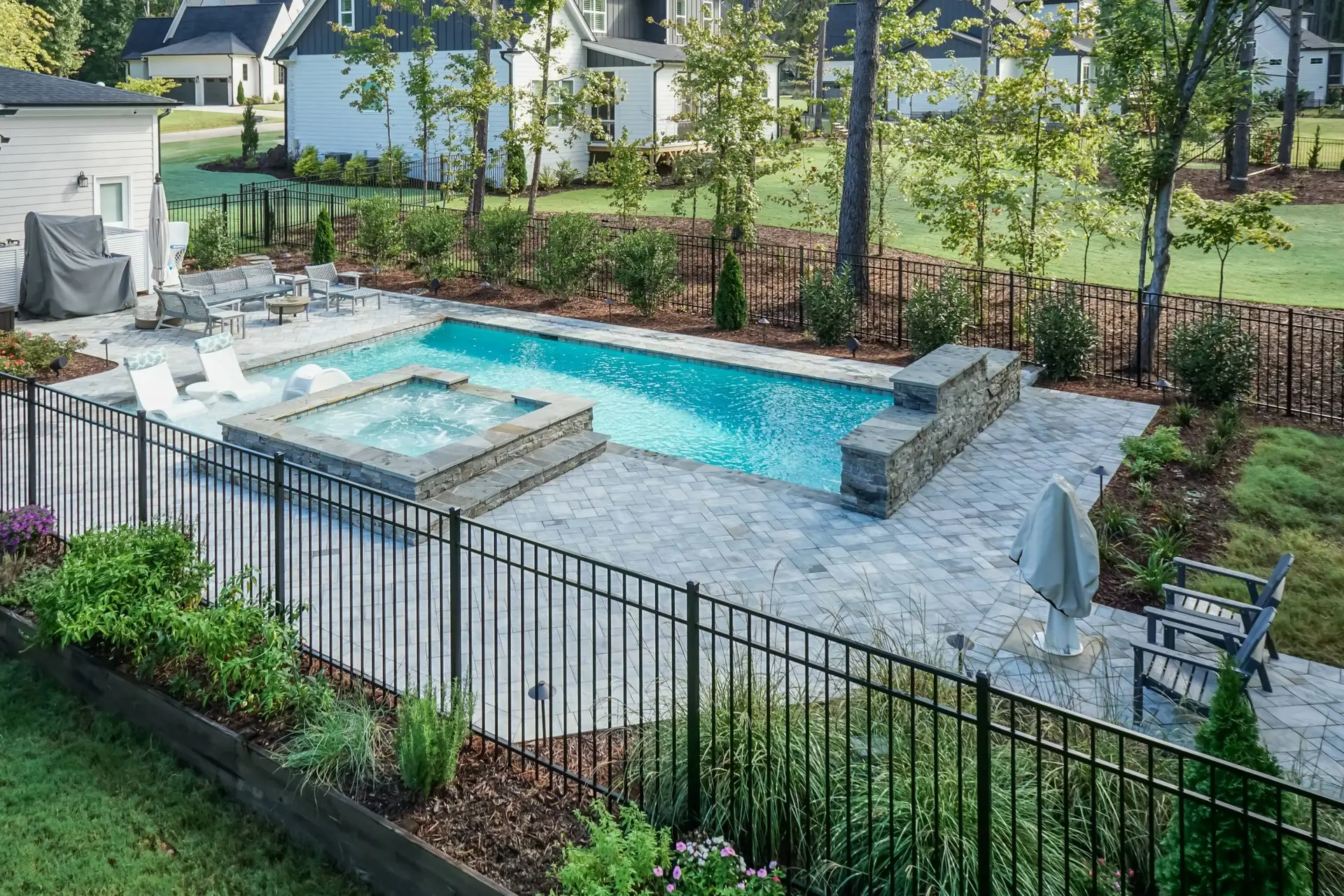 Toll Mill Vista Escape luxury pool with Cambridge pavers, water feature wall and spa - angled view Raleigh, NC